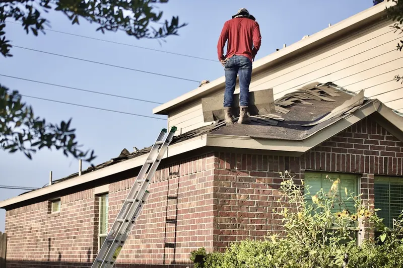 Professional roofer working on a residential roof in Westside